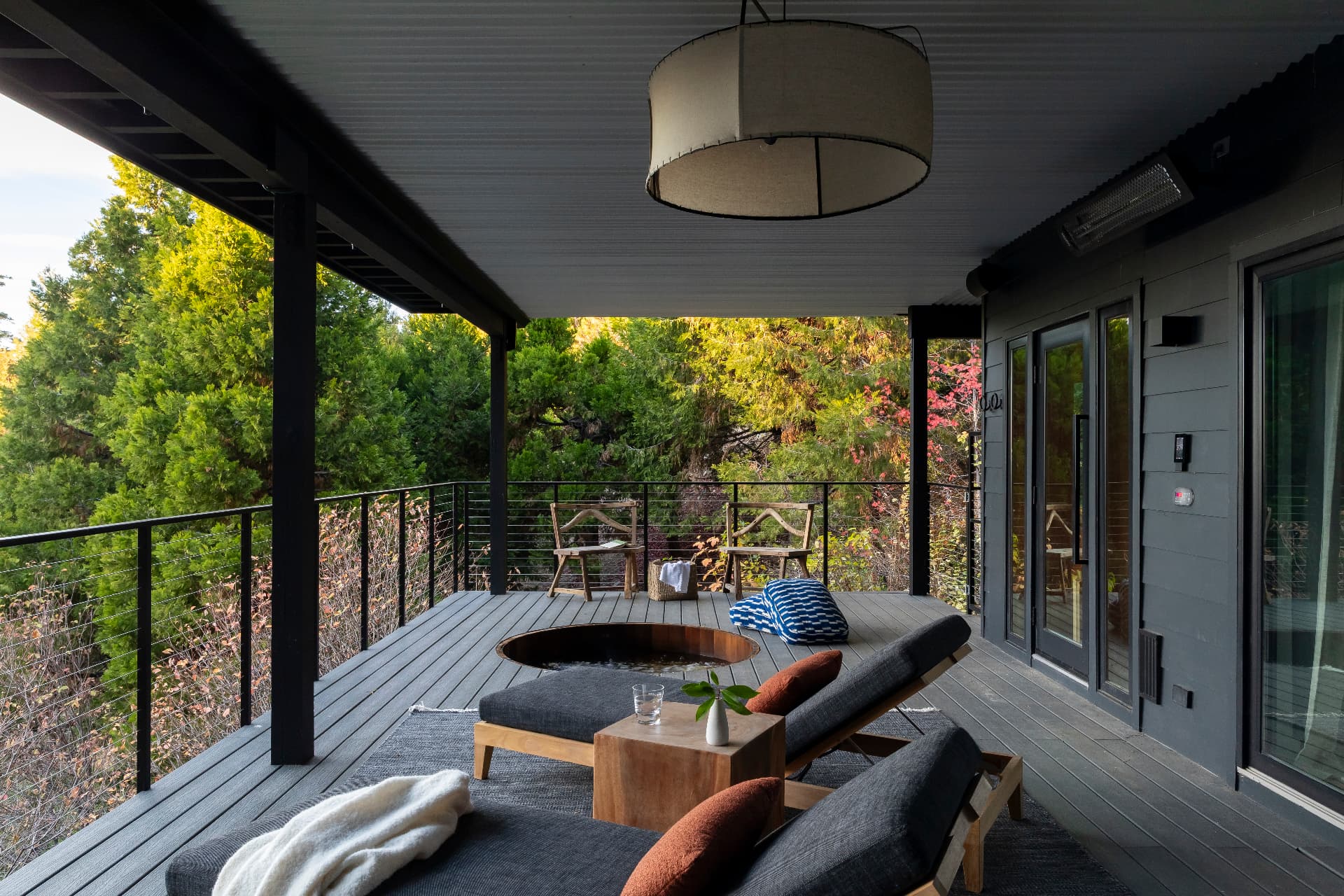 Outdoor cedar soaking tub on the covered deck overlooking the forest